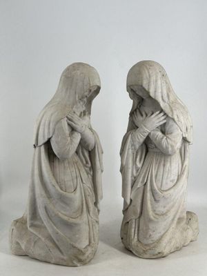 deux statues représentant une femme et un homme assis par terre