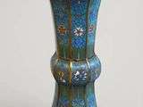 un vase bleu posé sur une table aux bordures dorées