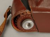 a brown leather camera case with a camera strap