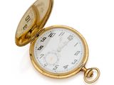 une montre de poche en or posée sur une surface blanche