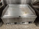 une photo d'une plaque de cuisson à gaz professionnelle dans une cuisine professionnelle