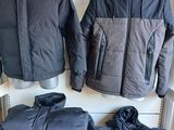 deux vestes et un pantalon sont posés sur une étagère dans une pièce