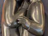statue of a man and woman hugging each other on a black background