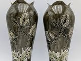 pair of vases with flowers and leaves on them on a white background