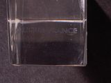 a bottle of perfume sitting on a black surface