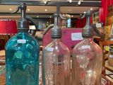 three different colored glass bottles on a table in a store