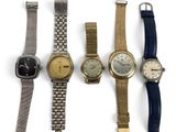 several different types of watches are lined up on a white surface
