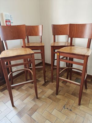 three wooden bar stools in a room with tile flooring