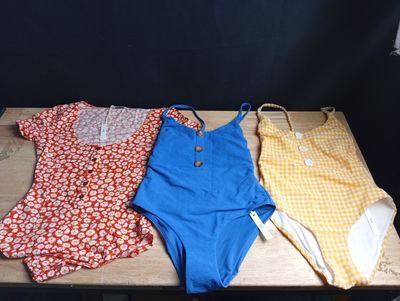 trois vêtements posés les uns à côté des autres sur une table