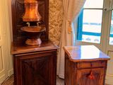 a wooden cabinet in the corner of a room with a lamp on it