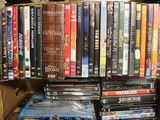many dvd ' s stacked on a shelf in a box