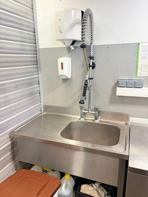 a sink and a trash can in a small room