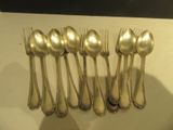 six cuillères en argent et six cuillères en argent posées sur une table