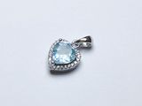 une image représentant un pendentif en forme de cœur en topaze bleue, orné de diamants, sur fond blanc