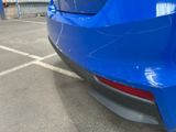 a blue car parked in a parking lot next to a building