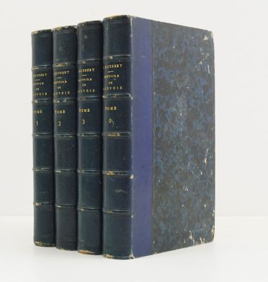 trois livres bleus empilés les uns sur les autres sur une surface blanche