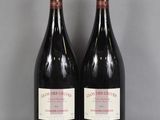 deux bouteilles de vin rouge posées sur une table en verre