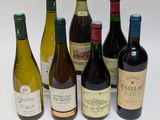 plusieurs bouteilles de vin sont alignées sur une surface blanche