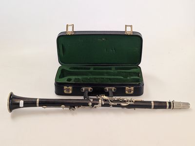 a black and silver clarinet in a case on a white surface
