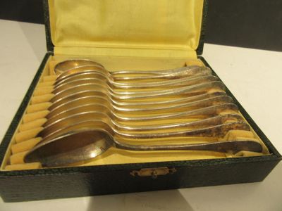 six cuillères dans un étui noir posé sur une table blanche