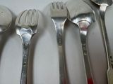 five forks and spoons sitting on a white table