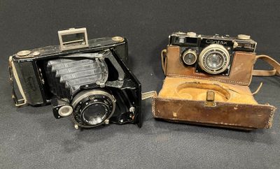 two old cameras sitting next to each other on a table