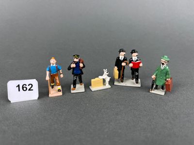 five figurines of people standing next to each other