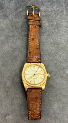 gros plan d'une montre-bracelet avec un bracelet en cuir marron