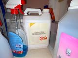 bottles of cleaning products sit on a shelf in a bathroom