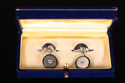 une paire de boutons de manchette dans un coffret posé sur une table