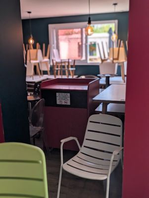 des chaises et des tables aux couleurs vives dans un restaurant aux murs rouges