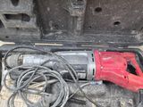 a red electric drill in a case on the ground