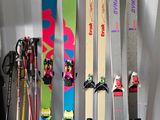 Plusieurs skis sont alignés contre un mur dans une pièce