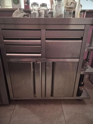 a stainless steel kitchen island with drawers and drawers on it