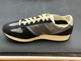 black and white sneakers with yellow laces on display on a table