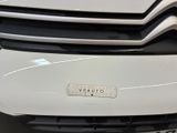 the front end of a white car with a sticker on it