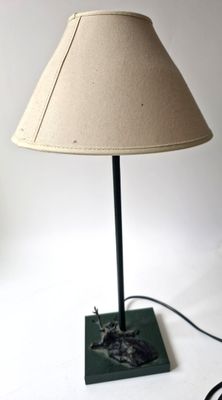 une lampe posée sur une table sur laquelle se trouve un chat