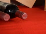 three bottles of wine sitting on a red table