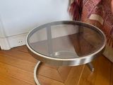 a small table with a glass top sitting on a hard wood floor