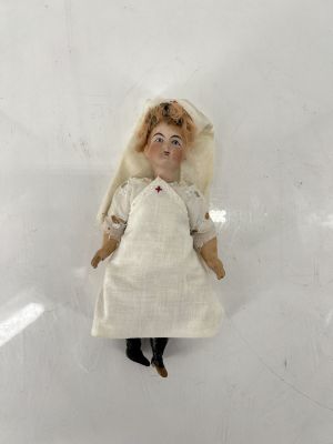 a doll that is laying down on a white surface
