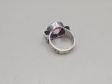 a close up of a silver ring with a purple stone in it