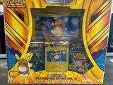 La boîte de cartes Pokémon est posée sur la table.