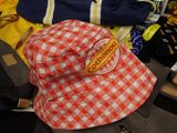 a red and white hat sitting on top of a pile of luggage
