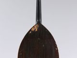 an old wooden instrument with a black body and brown strings