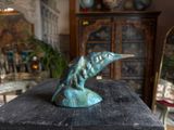 a statue of a bird sitting on top of a wooden table