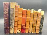 several old books are lined up in a row on a table