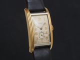 une image d'une montre-bracelet plaquée or avec un bracelet en cuir noir