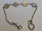bracelet à chaîne en argent orné de breloques, posé sur un fond blanc