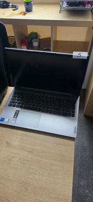 a laptop computer sitting on a desk in front of a chair