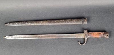 an old knife is laying on a table next to a knife